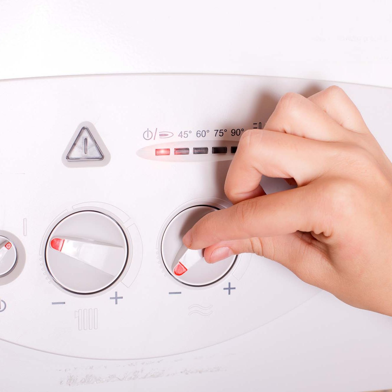 Close up of female hand turning on gas boiler for heating water